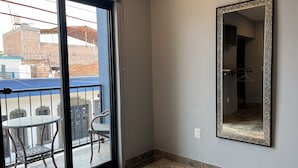 A room with a sliding glass door leading to a balcony with a table and chairs. - Hotel La Bikina (Tequila)