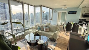 A modern apartment with a city view, a dining area, and a kitchenette. - Downtown High-rise Condo Amazing View+Pool+Hot Jacuzzi+Sauna+Gym+ free Parking (Vancouver)