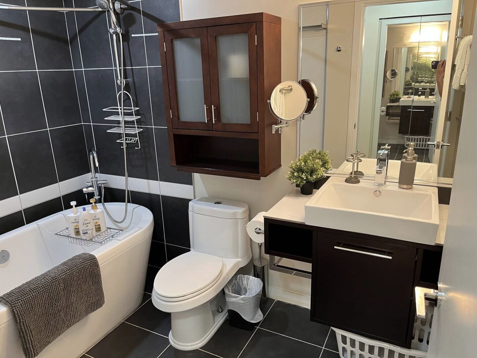 A modern bathroom with a bathtub, toilet, and vanity.