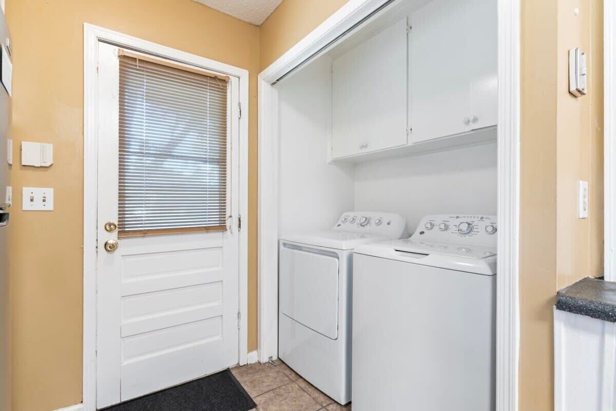 A laundry room with a door, a washing machine, and a dryer.