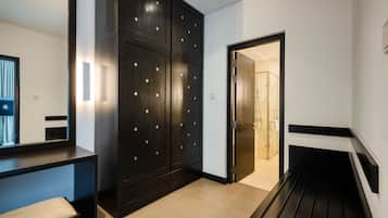 Une salle de bain moderne avec un meuble-lavabo en bois foncé, un banc et une cabine de douche en verre.