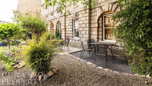A courtyard with a stone building, outdoor seating, and greenery. - The Admirals House - Central Bath & Free Parking! (Bath)