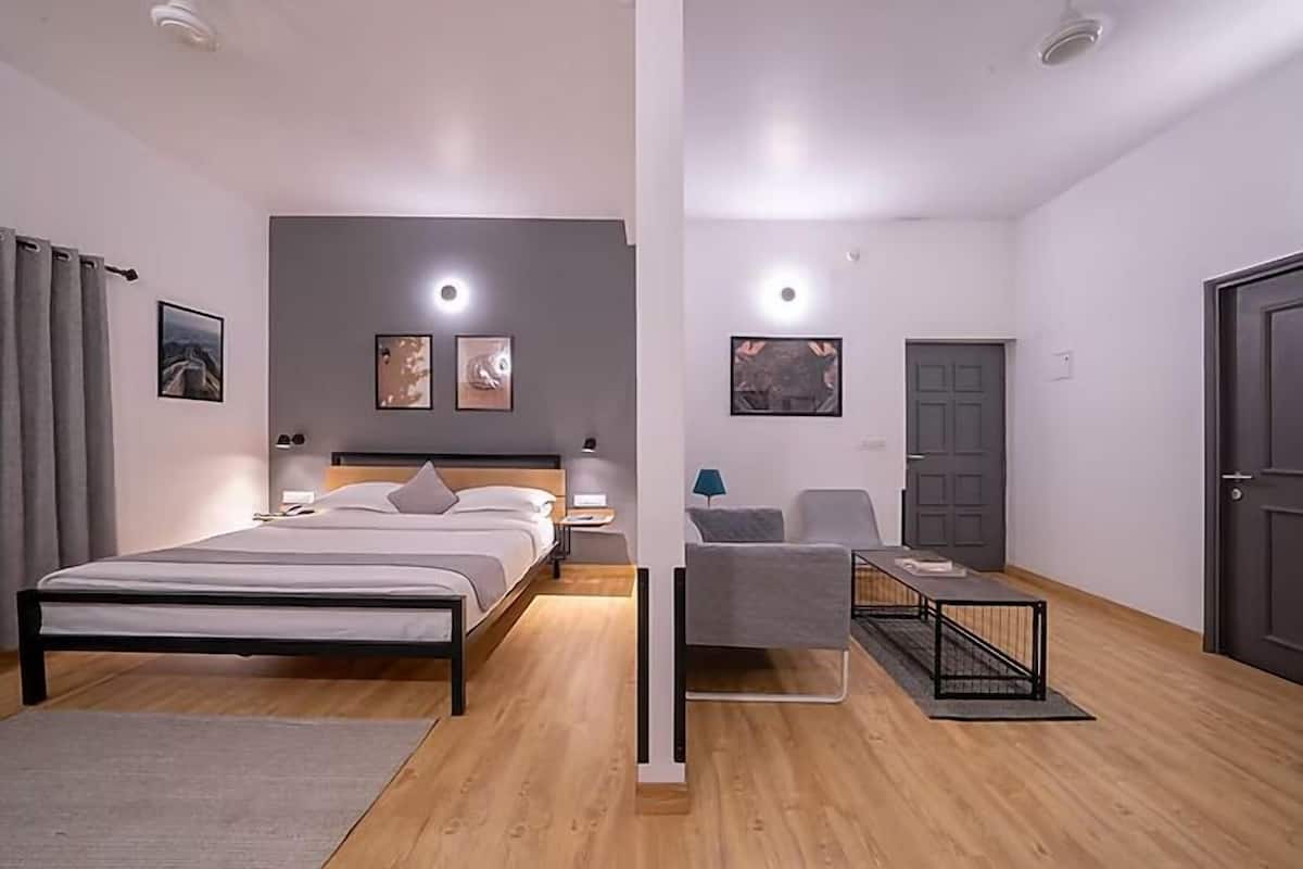 Un dormitorio moderno con una cama, mesitas de noche, un escritorio y una silla.