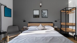 Une chambre d’hôtel moderne équipée d’un grand lit, d’un bureau, d’une chaise et d’une armoire.