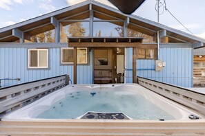 Un área de spa con hidromasaje y terraza de madera.