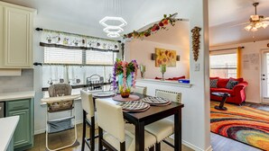 Un coin repas équipé d’une chaise haute, d’une table avec des sets de table et d’un vase rempli de fleurs.