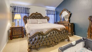 Une chambre à coucher avec une tête de lit capitonnée, une table de chevet avec une lampe et un miroir au mur.