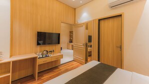 Un dormitorio moderno con cama, televisor, escritorio y armario.