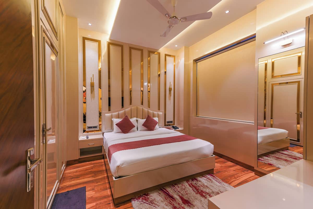 Ein modernes Hotelzimmer mit einem großen Bett, einem Deckenventilator und einem Spiegel.