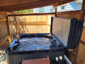Ein Whirlpool unter einem hölzernen Pergola im Garten.