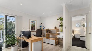 Work and rest in comfort with a large desk, bookshelf, and cozy bed area.