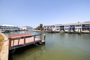 Une propriété située au bord de l’eau, dotée d’un quai, d’un grand bâtiment avec de nombreuses fenêtres et d’une construction plus petite à proximité.