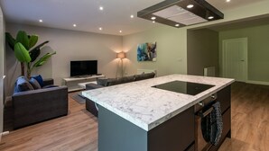 A modern kitchen with a marble countertop, a built-in stove, and a large island.