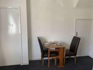 A compact dining area with a table and chairs, perfect for light meals or snacks.