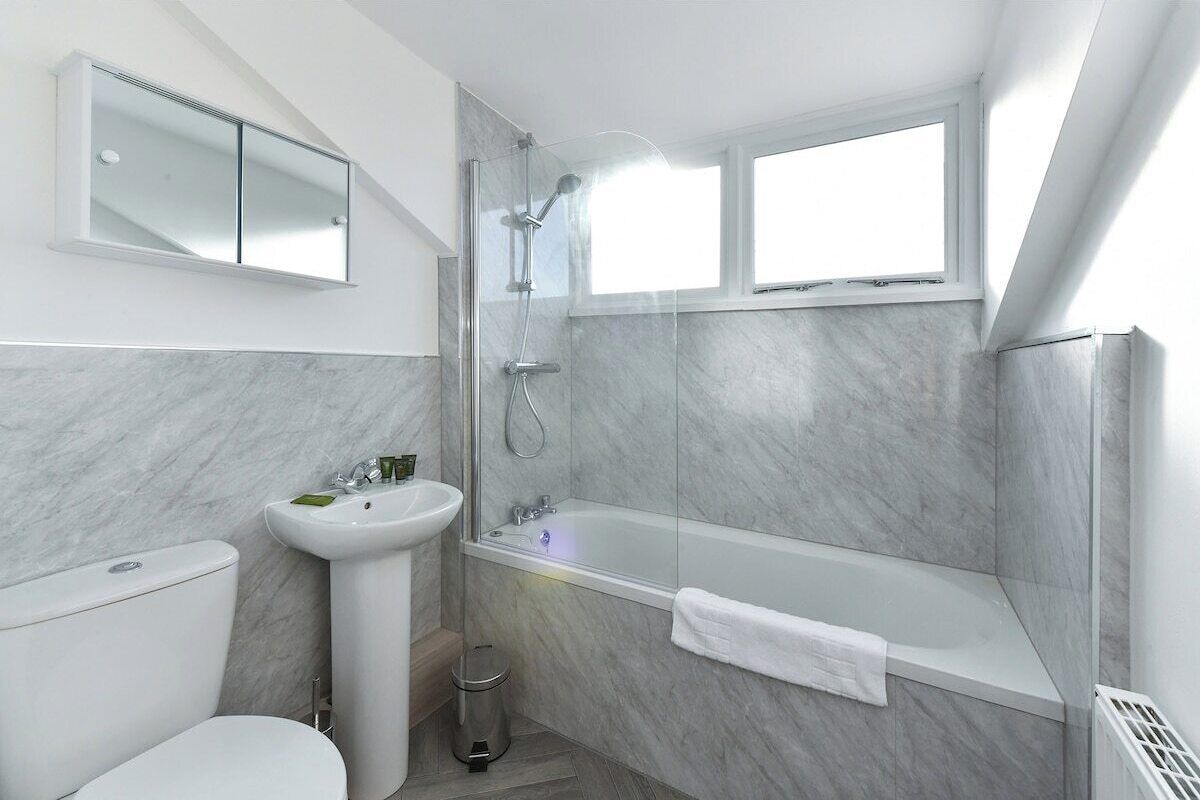 A modern bathroom with a toilet, sink, and bathtub.