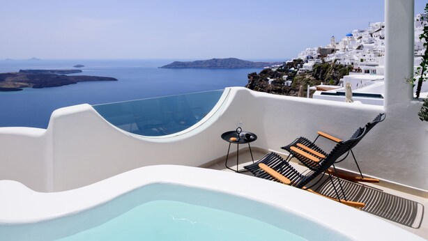 A pool area with a view of the sea and white buildings. - Aethria Suite with Caldera view (Santorini)