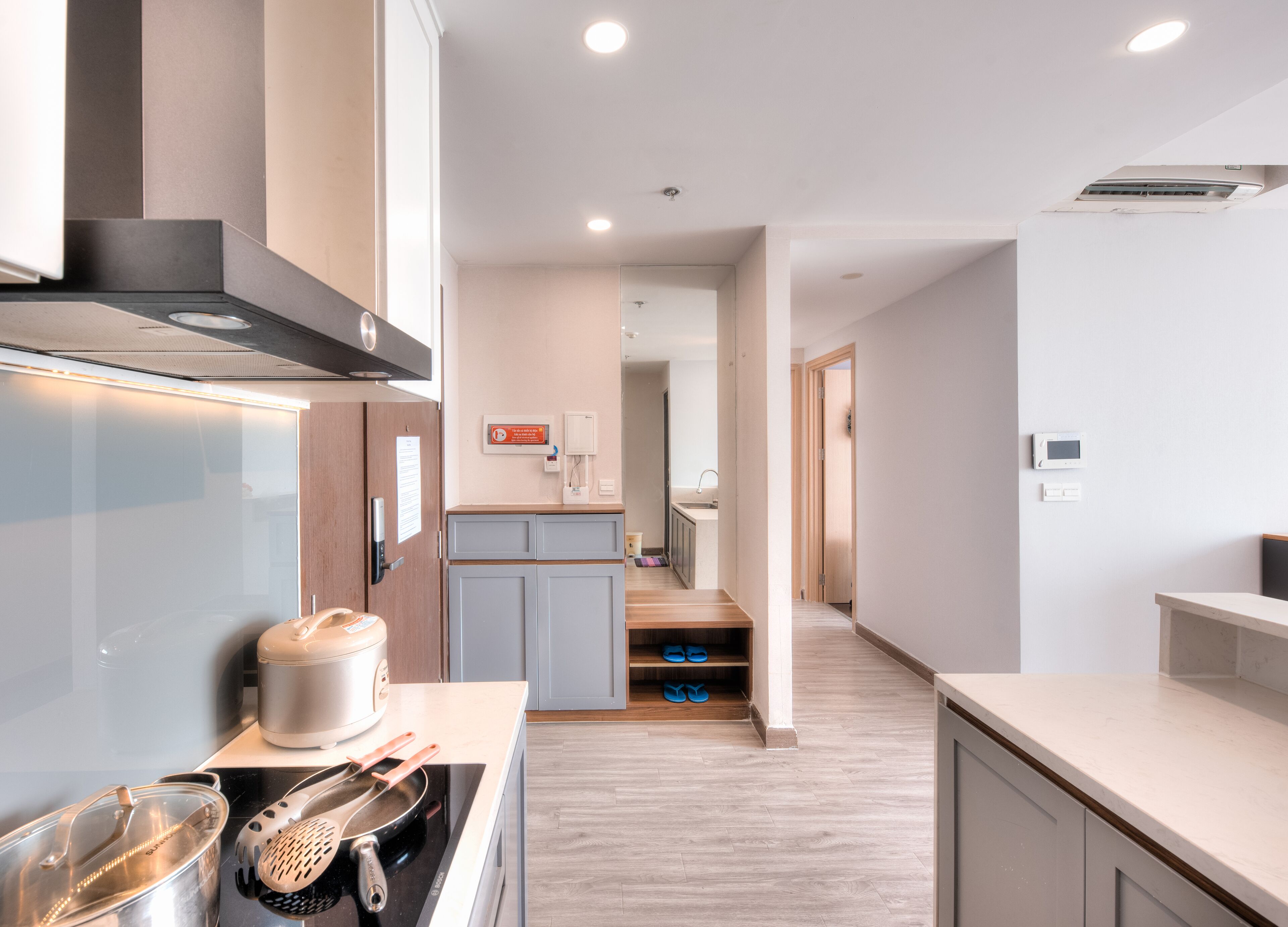 A modern kitchen with a built-in oven, a microwave, and a coffee machine. There is a wooden countertop and a sink with a faucet.