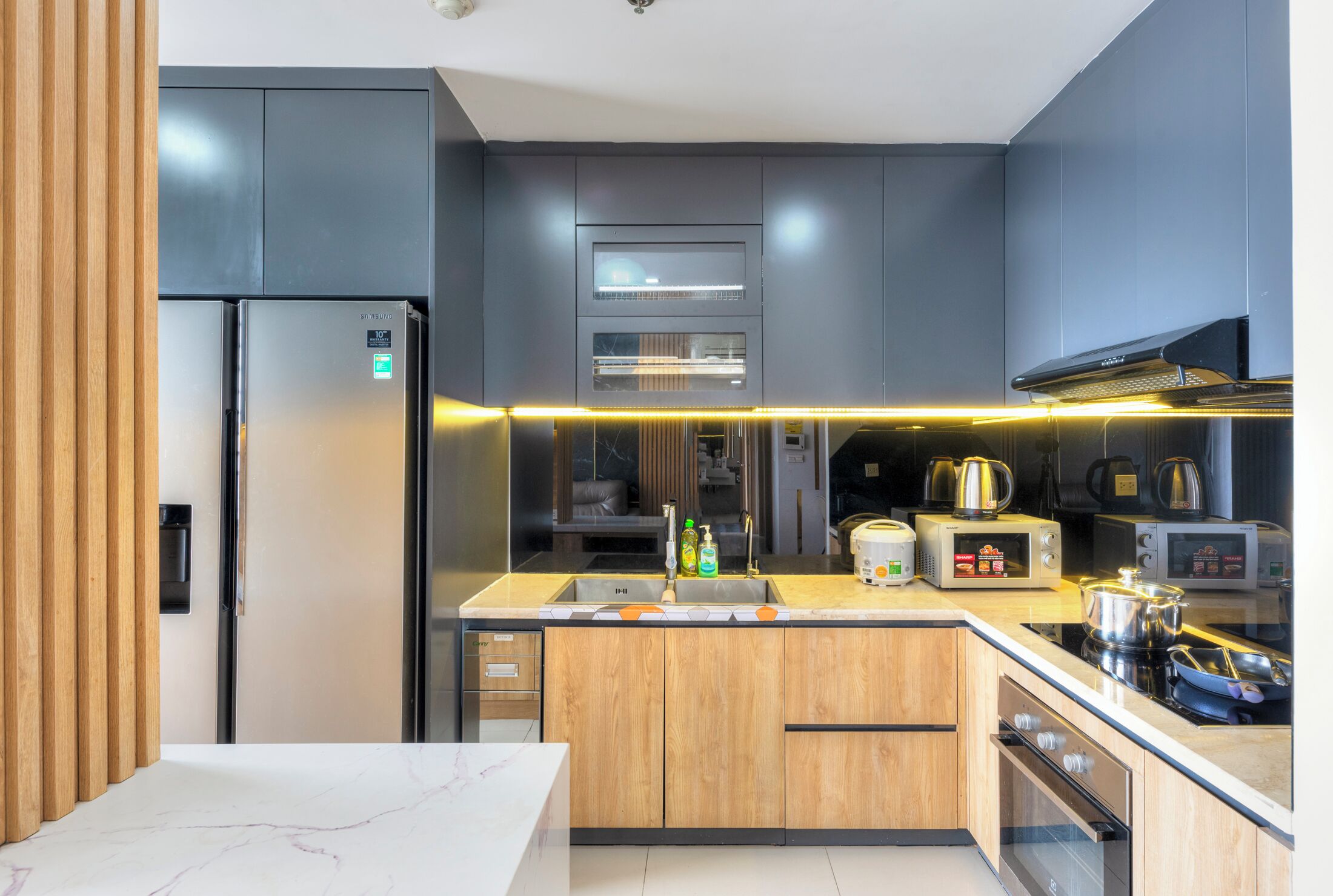 Una cocina moderna con refrigerador, microondas, tostadora y estufa integrados.