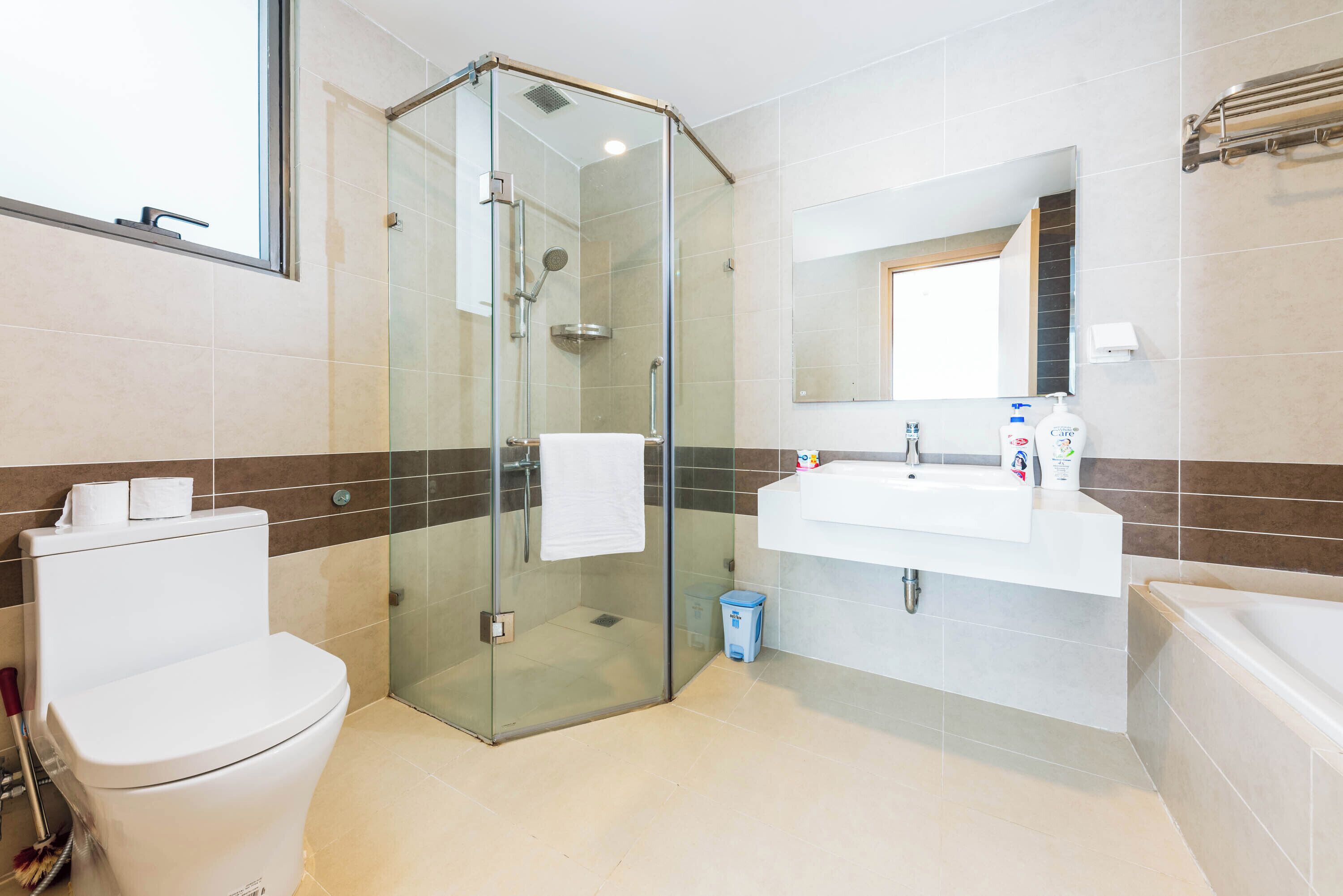 Ein modernes Badezimmer mit einer Duschkabine, einer Toilette, einem Waschbecken und einer Badewanne.