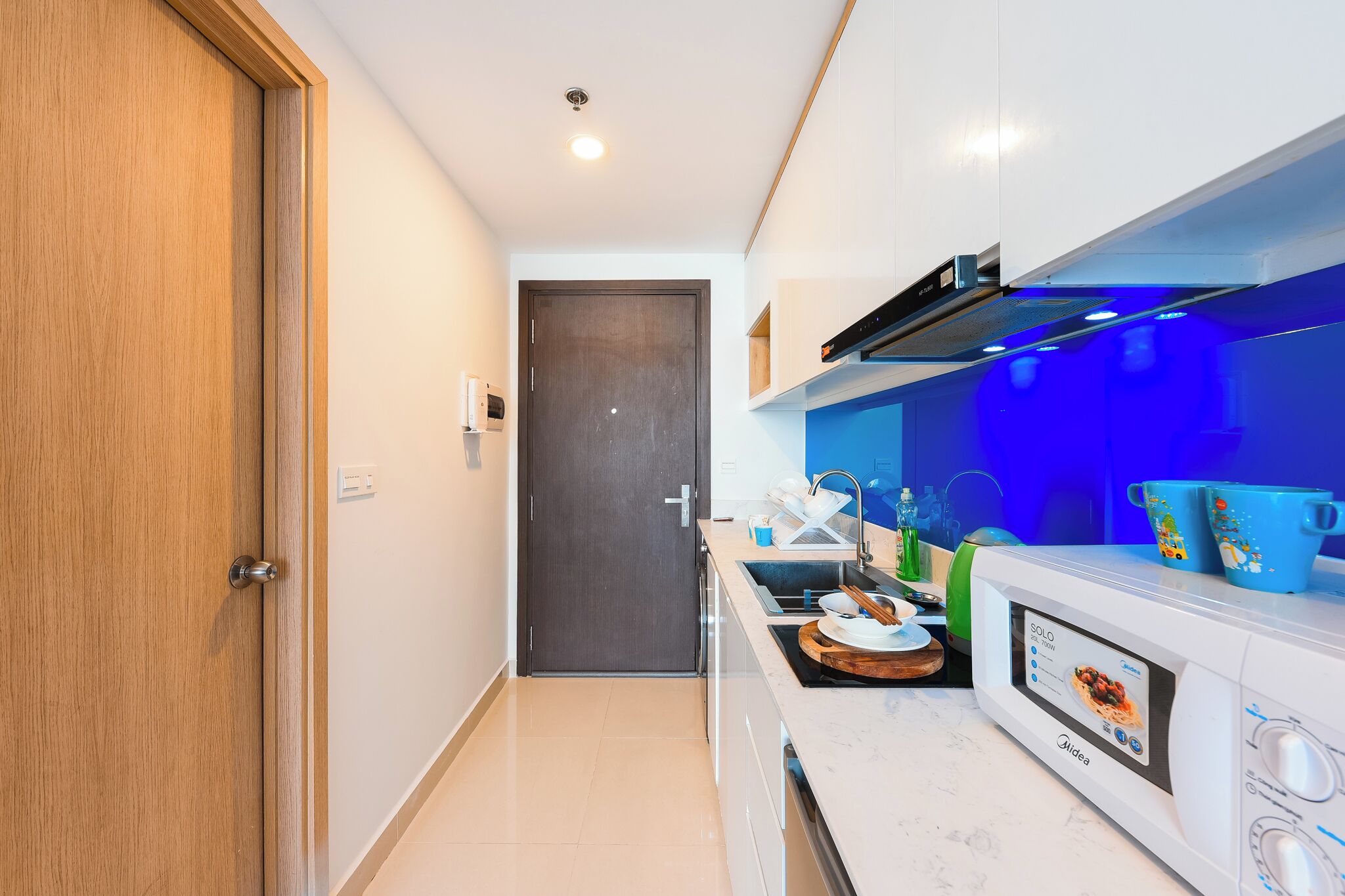 A modern kitchen with a microwave, sink, and cabinets.