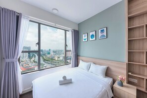A modern hotel room with a large window, a neatly made bed, and a city view. - REM Rivergate Garden Pool Signature Apartments (Ho Chi Minh City)
