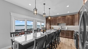 A kitchen with a large island, wooden cabinets, and a view of the lake. - Enjoy Sunsets at Fully Equipped 4BR-Lake Champlain (Colchester)