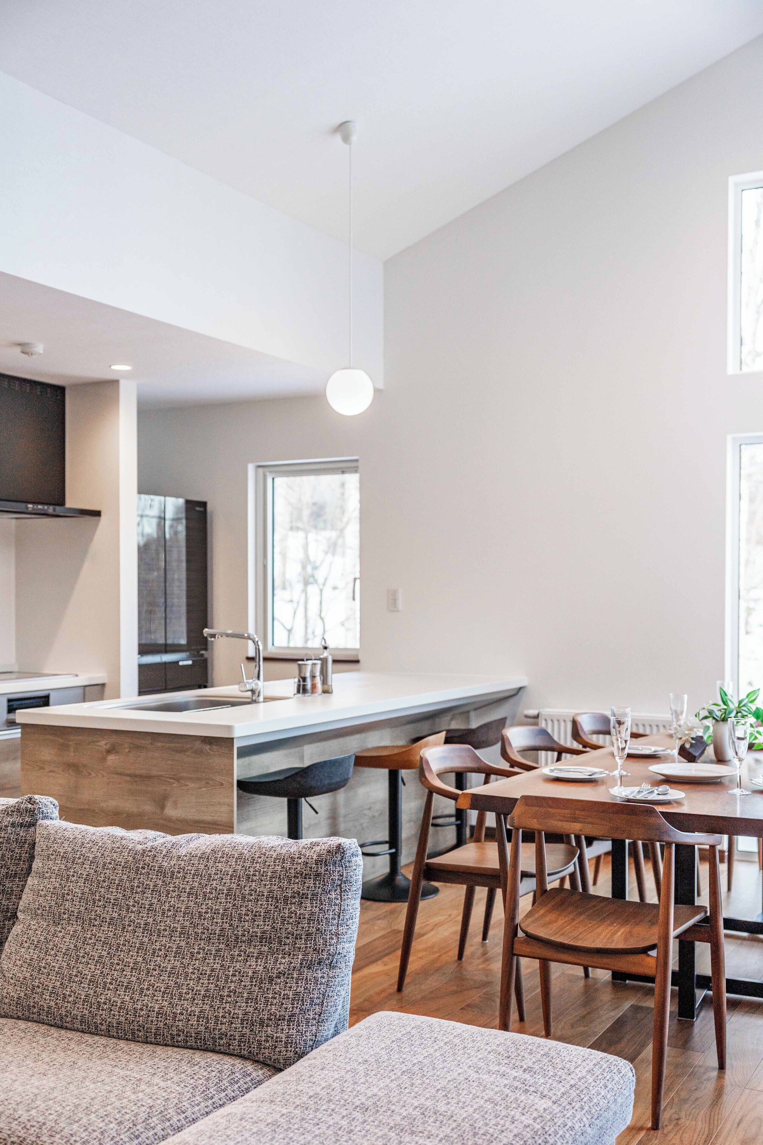 Une cuisine moderne dotée d’un îlot central, d’une table à manger en bois et de chaises.