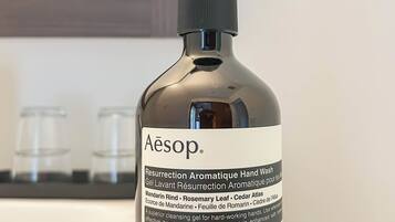 Eine Flasche Handseife mit dem Aufdruck 'Aesop' auf einem Holztablett.
