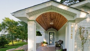 Une maison avec un porche, une porte et une boîte aux lettres.