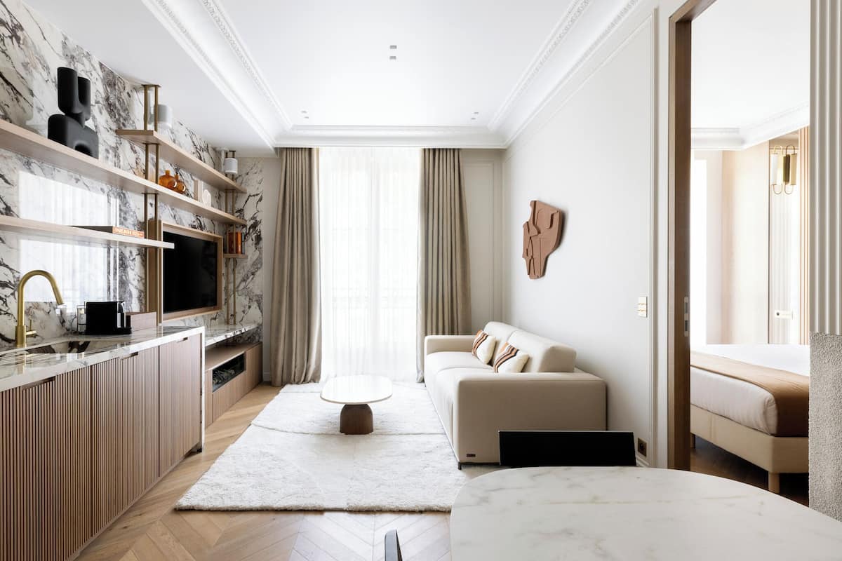A modern living room with a sofa, coffee table, and a TV on a wooden cabinet.