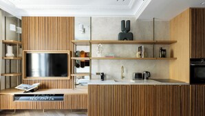 Una cucina moderna con mobili in legno, una TV integrata e un'isola centrale con lavello.