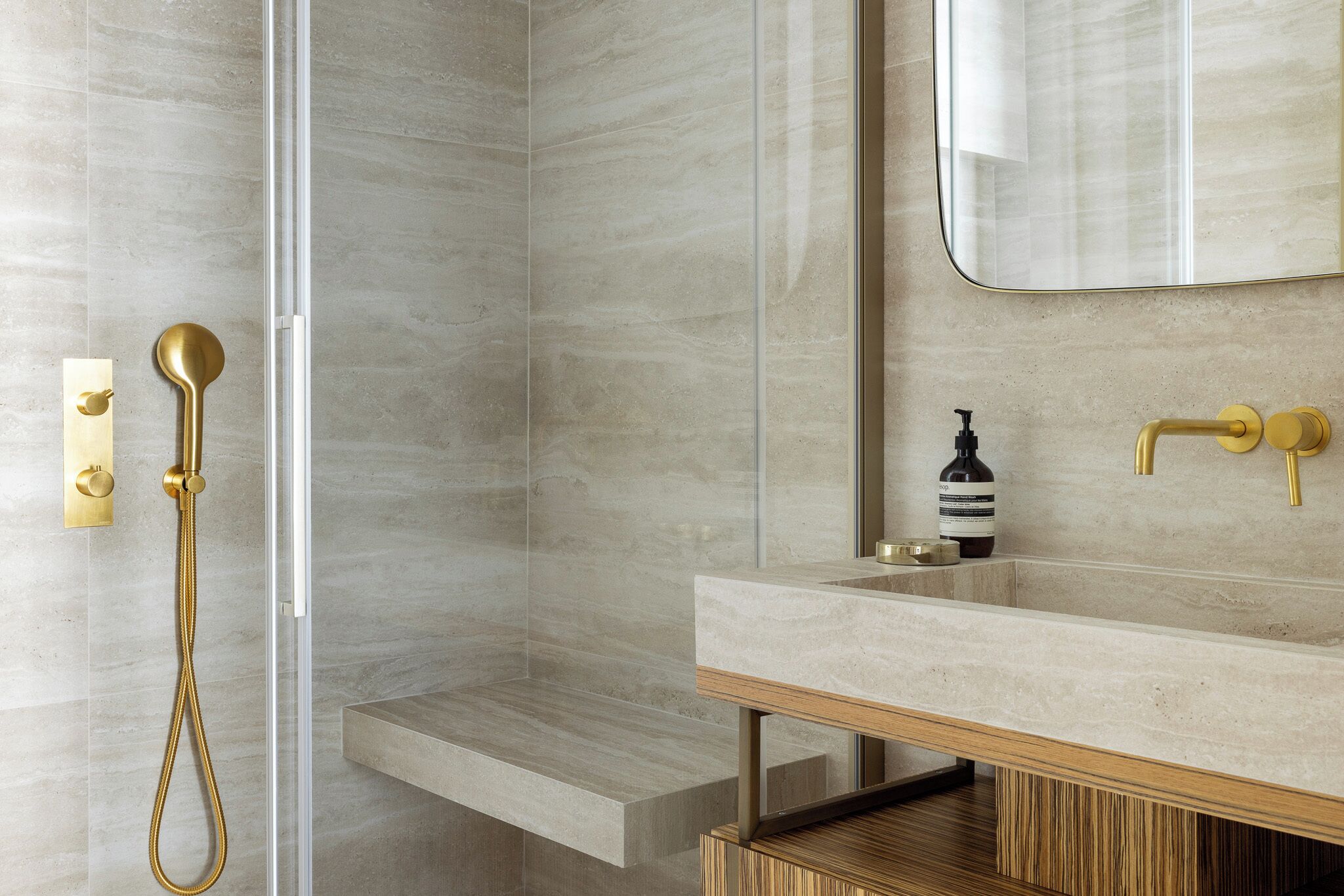 A modern bathroom with a glass-enclosed shower, a wooden vanity, and a large mirror.