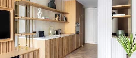 Una cocina moderna con armarios de madera, estantes integrados y una isla central.