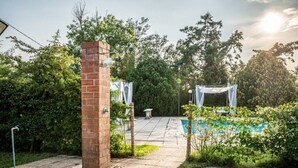 A brick pillar, a pool, and a covered area with a pergola. - Villa Santa Gabriella (Bagno di Gavorrano)