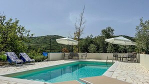 A rectangular swimming pool with clear blue water, surrounded by lounge chairs and umbrellas. - House in the Grapevine - Gabriel (Modolo)