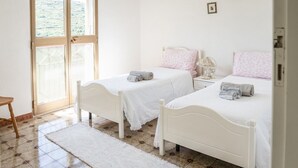 A bedroom with two beds, a window, and a door. - House in the Grapevine - Gabriel (Modolo)