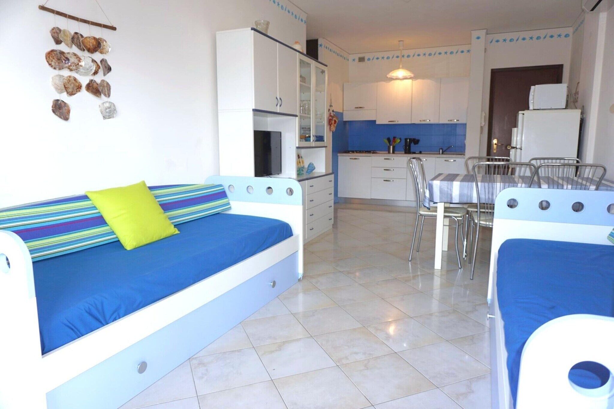 A room with a bed, a small kitchenette, a dining area, and a bathroom.