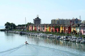 A waterfront with colorful buildings, a marina, and a boat in the water.