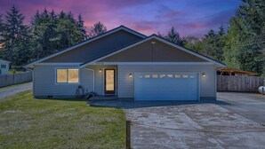 A single-story house with a garage, a front door, and a small porch area. - Beautiful family home, spacious living and only minutes from the beach. (Coos Bay)