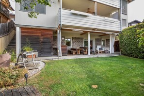 A modern two-story house with a covered patio, a stone wall, and a well-maintained lawn. - Apartment 'Obkircher' with Mountain View, Terrace, Garden and Wi-Fi (Nova Ponente)