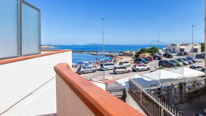 Vista costera con un estacionamiento, sombrillas de playa y cielo despejado.