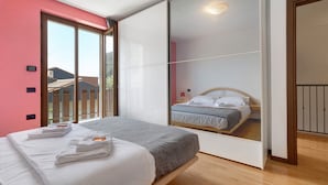 A bedroom with a bed, a sliding door, and a view of another room. - Villa 'Katzemburg 5+' with Lake View, Private Garden and Wi-Fi (Arco)