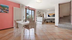 A spacious living area with a dining table, chairs, a sofa, and a staircase. - Villa 'Katzemburg 5+' with Lake View, Private Garden and Wi-Fi (Arco)