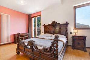 A bedroom with a large bed, a dresser, a nightstand, and a window. - Villa 'Katzemburg 9999' with Lake View, Private Garden and Wi-Fi (Arco)