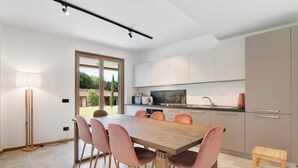 Une cuisine moderne avec un coin repas, une grande fenêtre et une vue sur la verdure.
