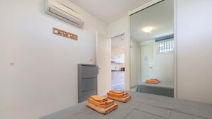 Een hotelkamer met een bed, een kledingkast, een airconditioning en uitzicht op de keuken.