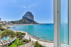Une vue sur la côte, avec une formation rocheuse imposante, une plage et une promenade.