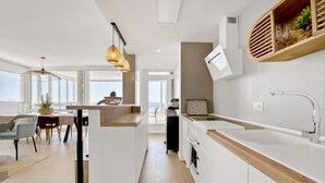 Eine moderne Küche mit weißen Schränken, einer Holz Arbeitsplatte und einem eingebauten Backofen.