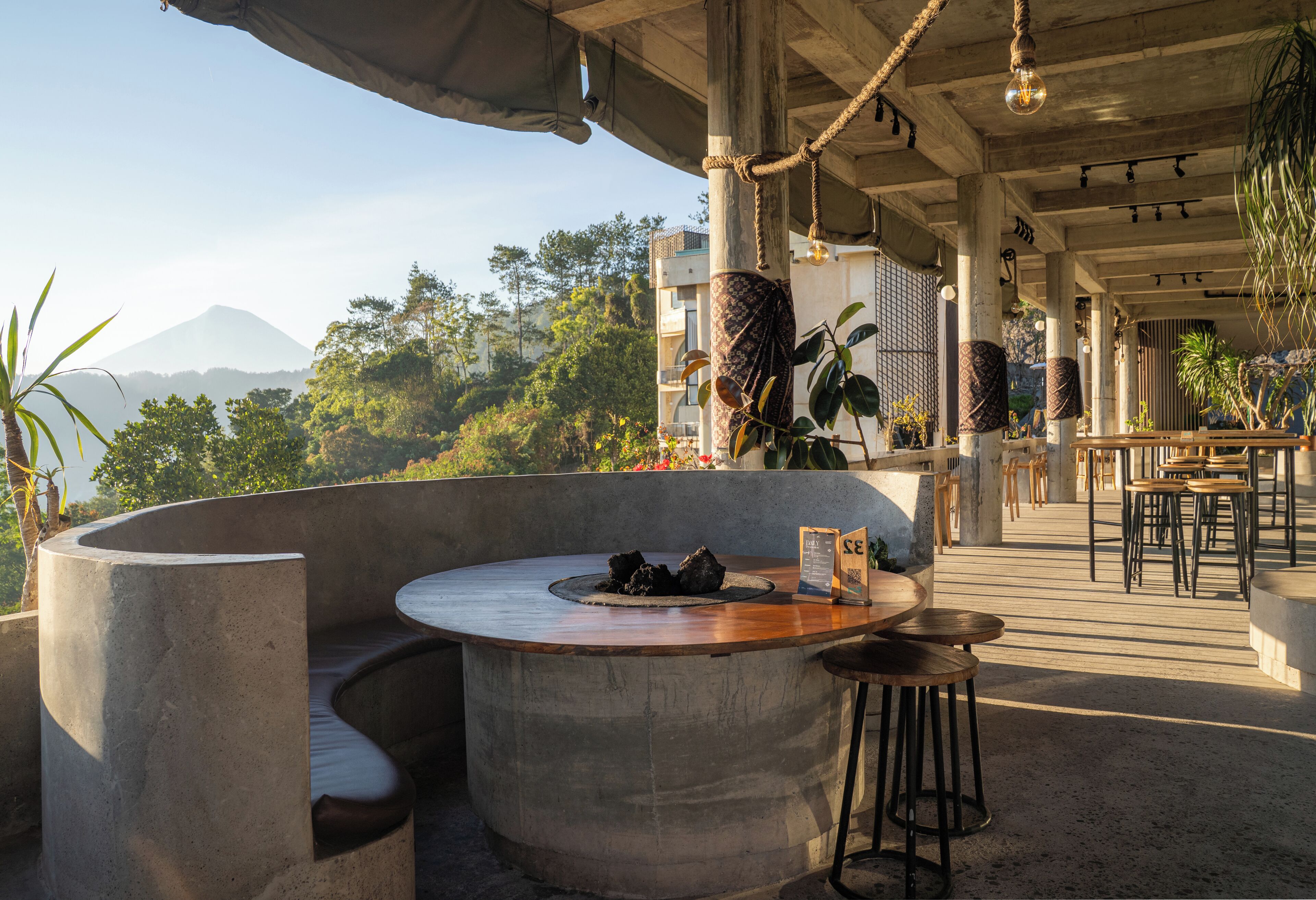 A curved bar area with a wooden countertop, seating, and a menu stand.