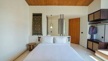 A modern bedroom with a large bed, a wooden ceiling, a hanging light fixture, and a wardrobe with a mirror.